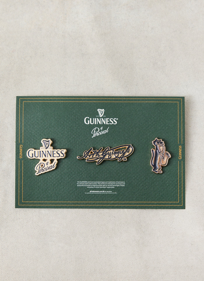 The Guinness x Percival 3 Pack Pins displayed on a green presentation card, featuring gold-tone metallic enamel pin badges.