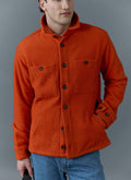 A model wears the Percival orange Casentino wool Blanket Overshirt with blue jeans against a grey background.