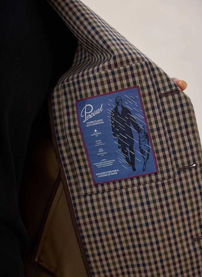 A close-up of the interior label and Watcher Check lining inside the waterproof Carter Cropped Jacket from Percival.