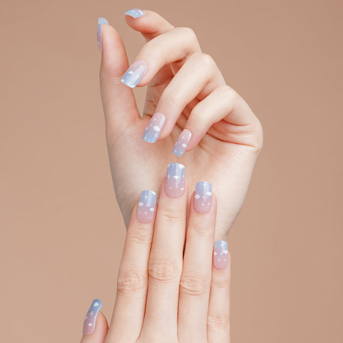 Stickers ongles gel Celiora bleu ciel avec nuages blancs, étoiles et base rosée