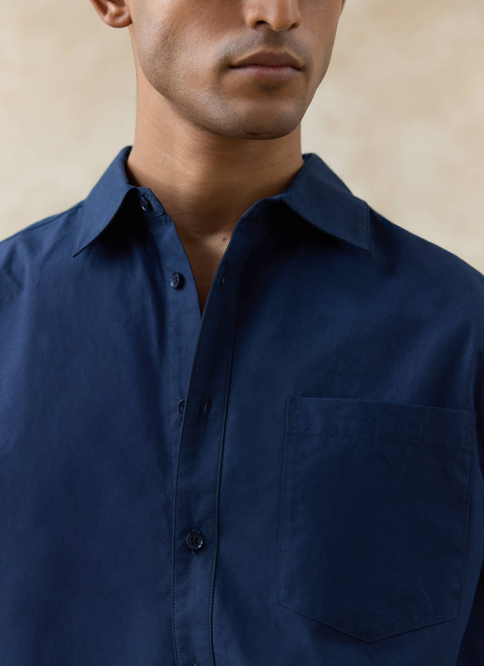 Close-up of the navy cotton Percival Dali Relaxed Poplin Shirt, highlighting the crisp fabric, collar, and chest pocket.