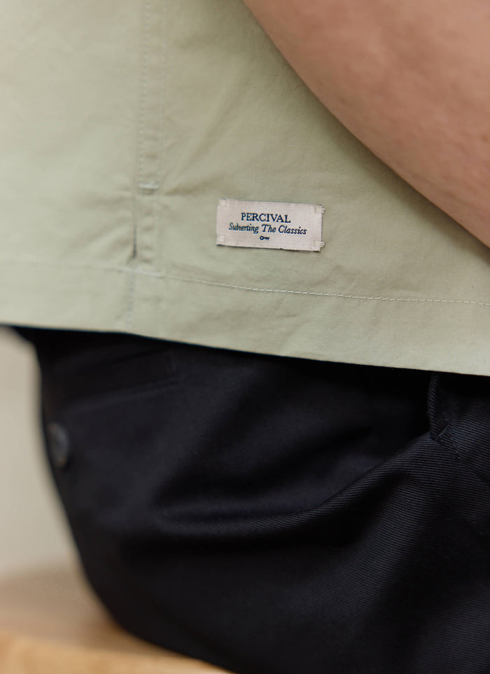 Pistachio cotton Percival Daniel shirt with 'Subverting the Classics' label. Want more? Check out SS26.