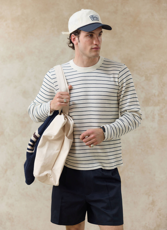 Percival Ernie waffle long sleeve tee in cream stripe worn with the cream Donovan soft trucker cap and navy shorts.