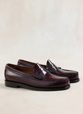 G.H. Bass Easy Weejun Larson flag penny loafers in polished wine leather against a neutral background.