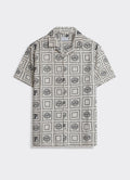 Percival Heaton Shirt in cream and black, a short-sleeved shirt with a tiled sun motif and Cuban collar, shown flat.