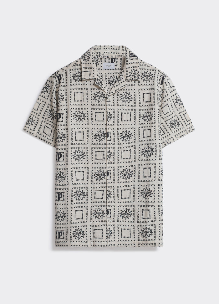 Percival Heaton Shirt in cream and black, a short-sleeved shirt with a tiled sun motif and Cuban collar, shown flat.