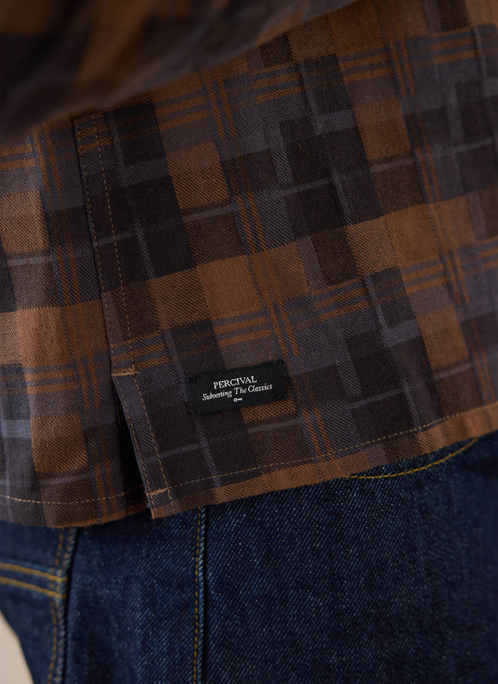 Close-up of the brown check Percival shirt, showing the brand label detail.