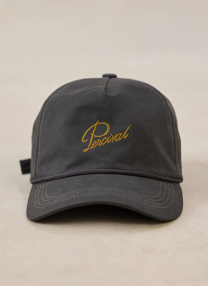 A close-up of the charcoal Percival Luther Soft Trucker Cap with gold embroidery on the front.