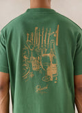 Forest green Percival Marley oversized T-shirt, featuring a dinner party back graphic, shown from behind on a model.