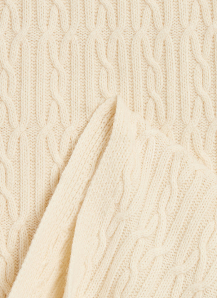 A detailed close-up of the Percival Melville Cable Knit Scarf in ecru, showcasing the intricate diagonal wool knit.