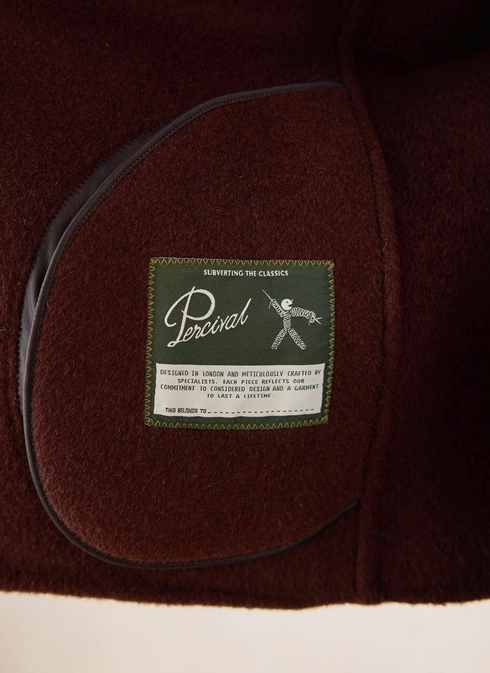 A close-up of the interior brand label inside the brown fleck overshirt from Percival.