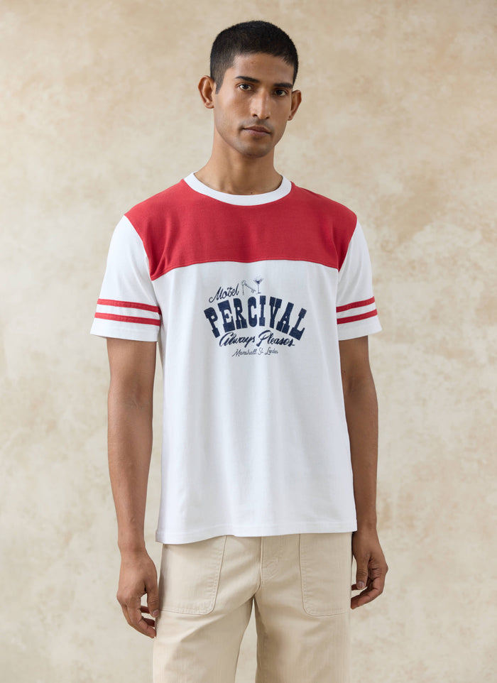 A model wearing the white and red Motel Percival T-Shirt in organic cotton, with a contrast yoke and vintage chest print.