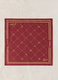 The Guinness x Percival burgundy silk neckerchief flat-laid, showing the gold print and border.