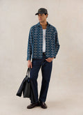 A model wears the navy Percival Nolan Jacquard Boxy Shirt with dark jeans, holding a black tote bag.