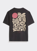 The Percival Palms T-Shirt in washed black, featuring a large hand-drawn cream palm and rosy sun graphic on the back.