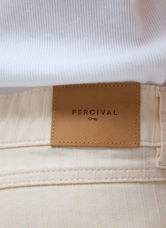 A close-up shot of the Percival leather patch and herringbone texture on the ecru Rocco 5 Pocket Trousers.