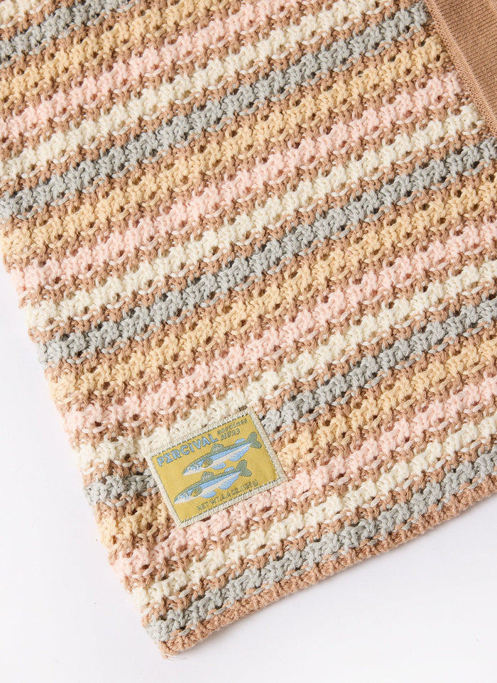 Close-up of the Percival Sari Stripe Knitted Shirt, showing the multicoloured cotton knit and unique fish brand label.