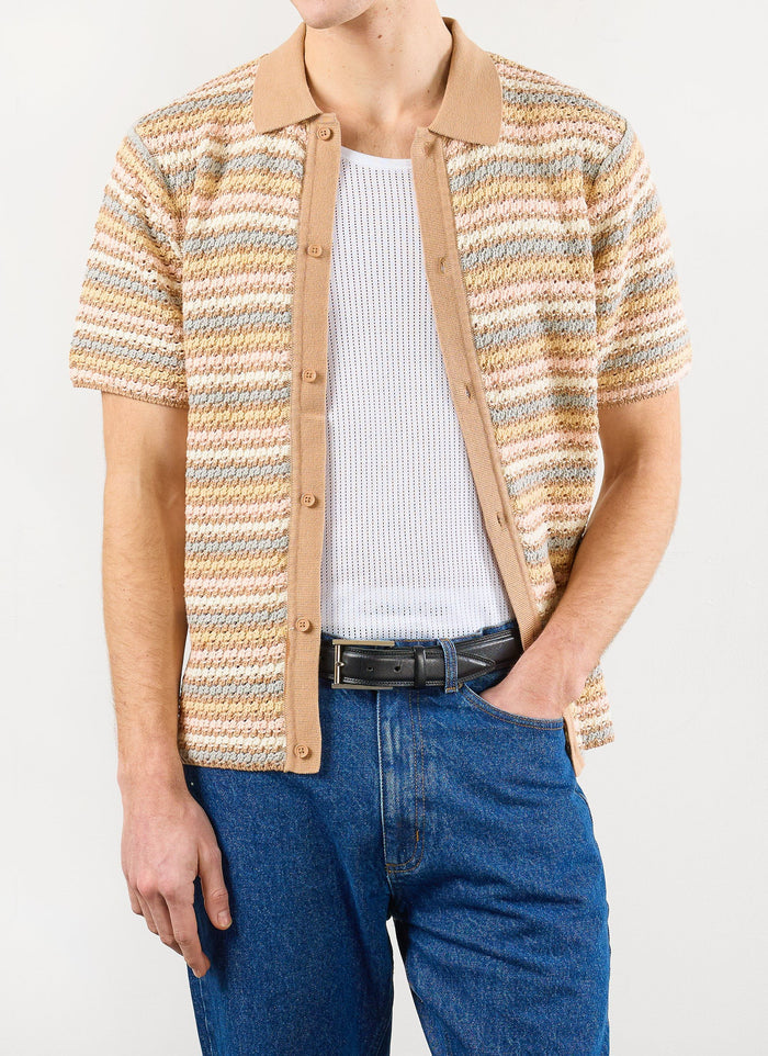 Model wearing the Percival Sari Stripe Knitted Shirt in ecru with a white vest and blue jeans.
