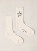 Pair of Guinness x Percival cream ribbed crew socks featuring green branding and text details.