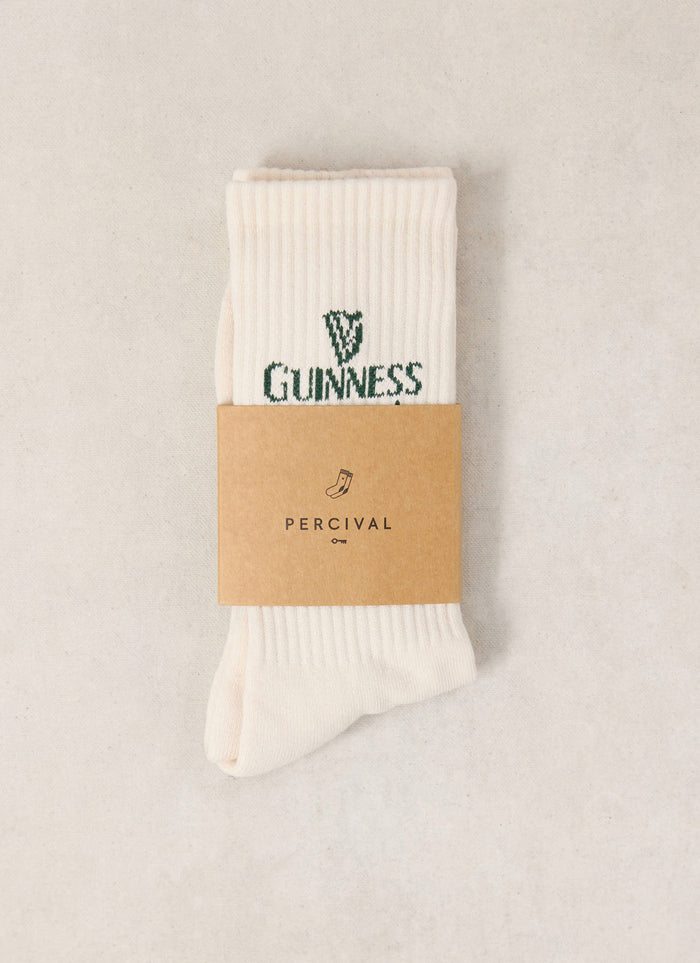 The Guinness x Percival cream ribbed crew socks featuring green branding and a branded paper band.