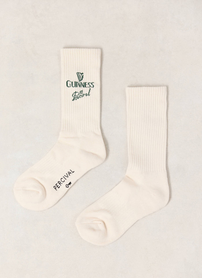 A pair of cream Guinness x Percival ribbed crew socks featuring green co-branded logo detailing.