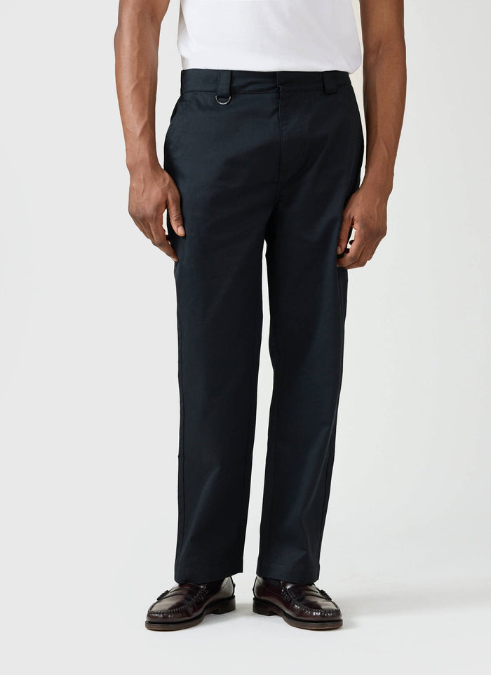 A model wears the black Straight Leg Twill Trousers by Percival, styled with a white t-shirt and leather loafers.