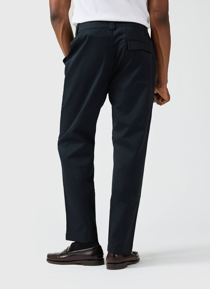 A model seen from behind wearing the black Straight Leg Twill Trousers by Percival, styled with dark loafers.