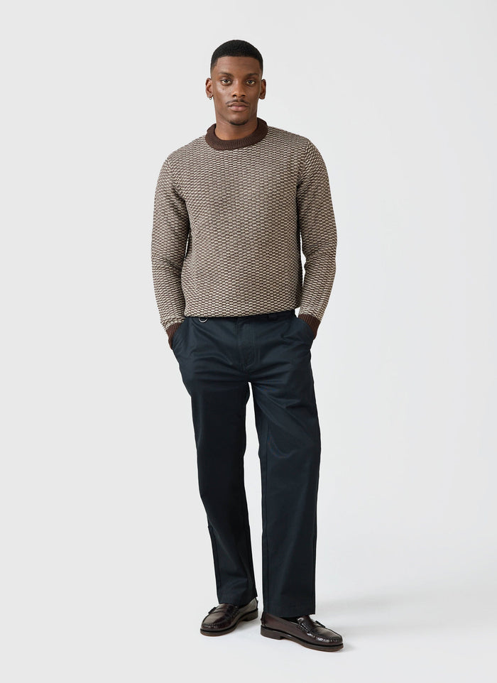 A model styles the Percival Straight Leg Twill Trousers in black with a textured brown jumper and dark loafers.