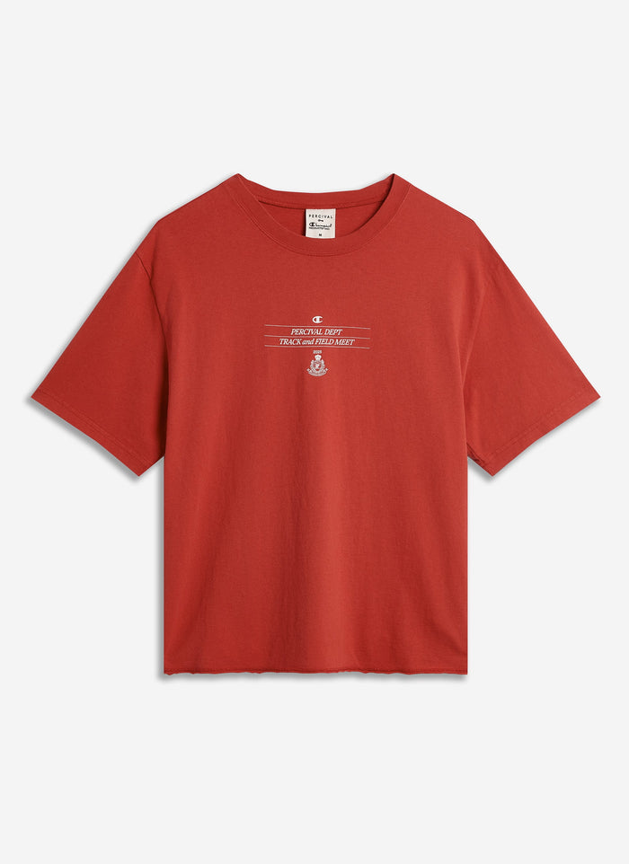 The red Track and Field raw hem t-shirt from the Percival x Champion collaboration, laid flat against a white background.