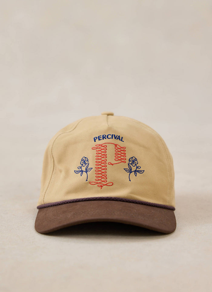 A close-up of the tan Percival Tucker soft trucker cap, showing the detailed embroidery and dark brim.